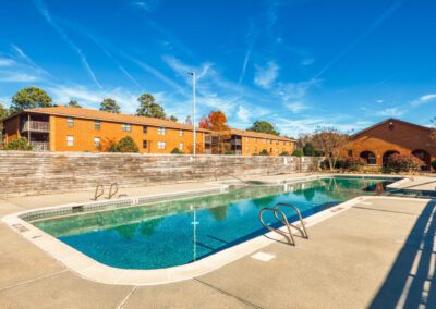 A peaceful park pool surrounded by trees, offering a natural retreat at the edge of the woods.